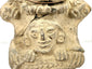 Close-up of lower sculpted face on beige earthenware with hand reliefs and fracture line