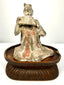 Ancient Chinese Tang Dynasty terracotta seated female musician playing a traditional pan flute, circa 618–907 CE.
