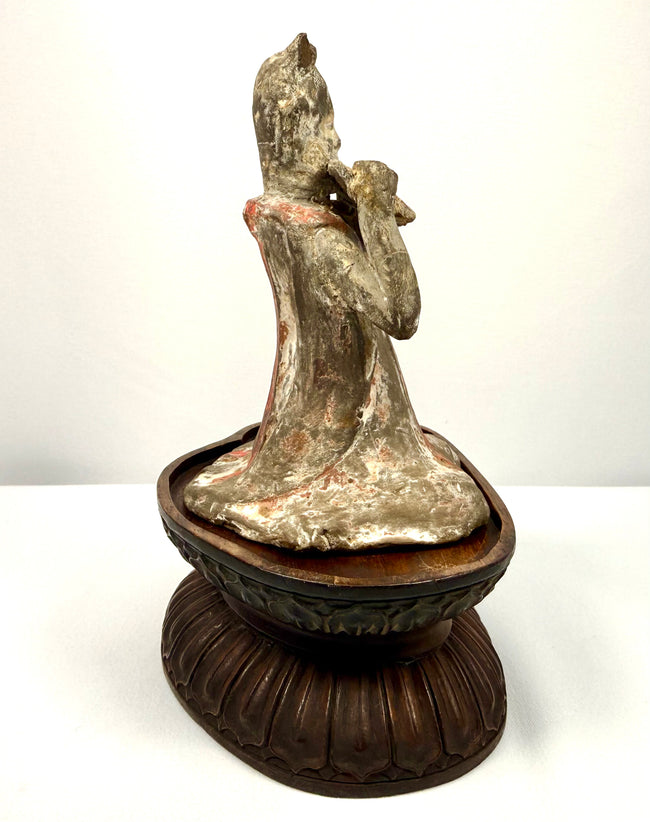 Ancient Chinese female court musician holding a pan flute, mounted on a later-added carved wooden display stand.