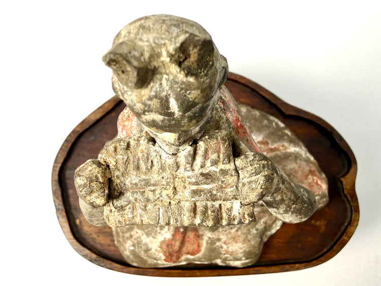 High-angle close-up of ancient terracotta court musician with pigment