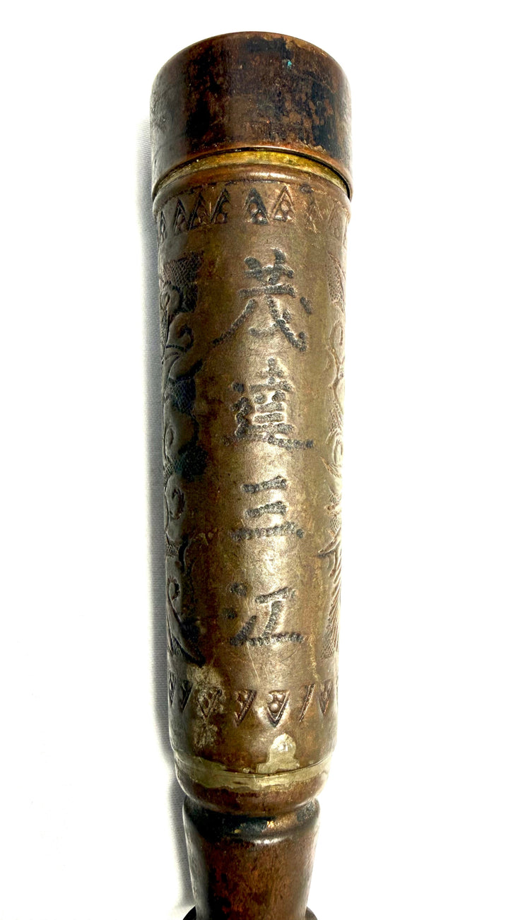 Frontal detail of engraved Chinese characters and triangular patterns on bronze candle holder