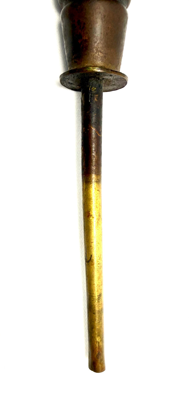 Close-up of tarnished metal collar connecting to slender brass rod on antique candle holder