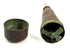 Disassembled antique candle holder showing internal cross-shaped support structure and patina