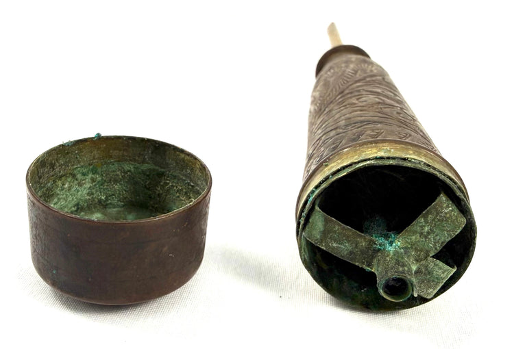 Disassembled antique candle holder showing internal cross-shaped support structure and patina