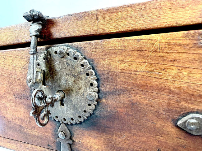 Antique Asian wooden lockbox with an original functional iron lock, elaborate metal hardware, and aged elmwood construction.