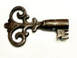 Close-up of ornate hand-forged iron skeleton key with intricate scrollwork bow and bitted end