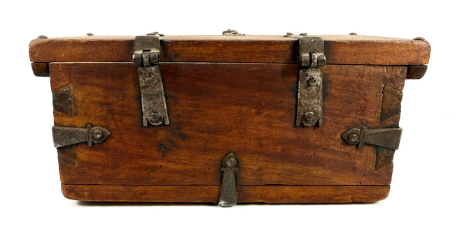 Historic Himalayan wooden lockbox with hand-forged iron hinges, heavy metal straps, and traditional dovetail joinery.