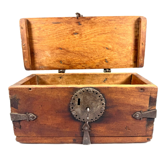 Antique wooden travel chest with original wrought iron fittings, visible craftsmanship, and naturally aged surface texture.