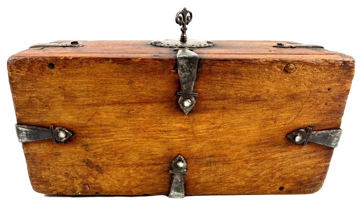 Rear view of antique chest featuring central vertical iron latch with fleur-de-lis finial and horizontal bands