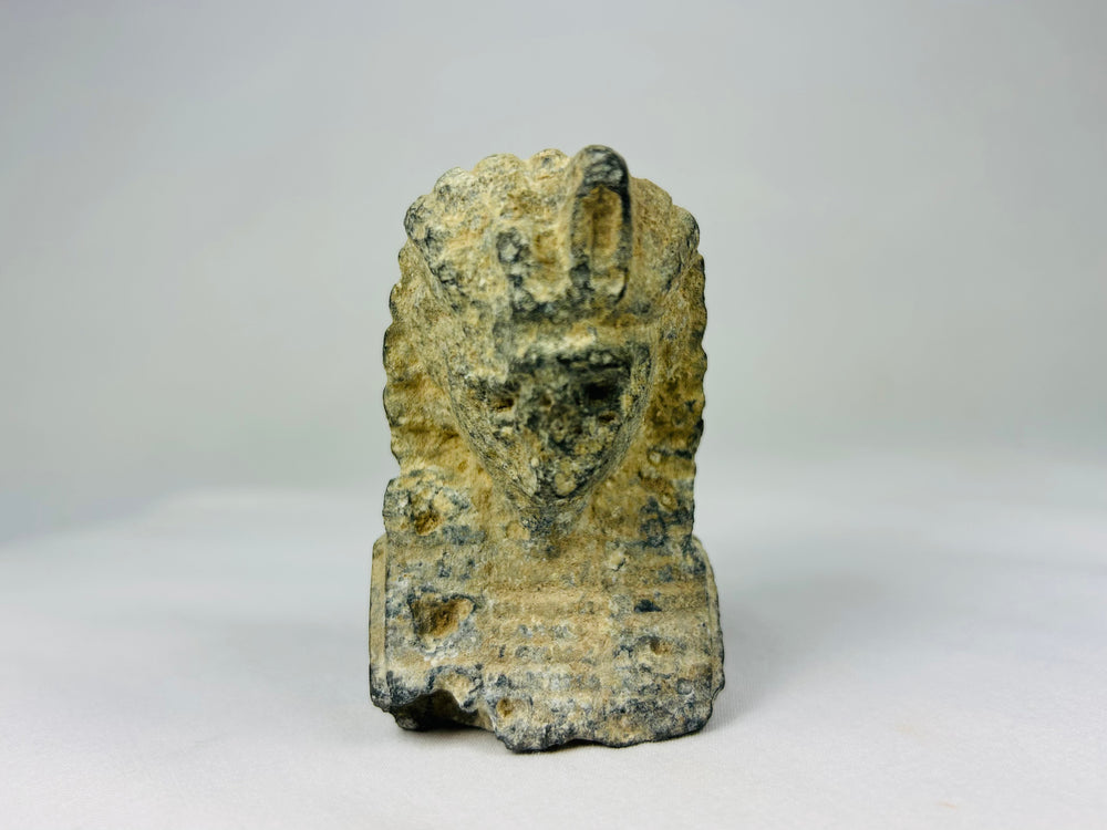 Limestone carving of an Egyptian pharaoh’s head with nemes headdress and uraeus, European Grand Tour era circa 1800–1920, displayed on a neutral backdrop.