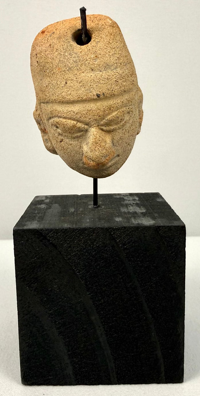 Ancient Mesoamerican terracotta amulet head with stylized headdress and almond eyes