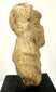 Archaeological fired-clay human figure fragment with an unfinished reverse, surface weathering, and losses to the lower body.