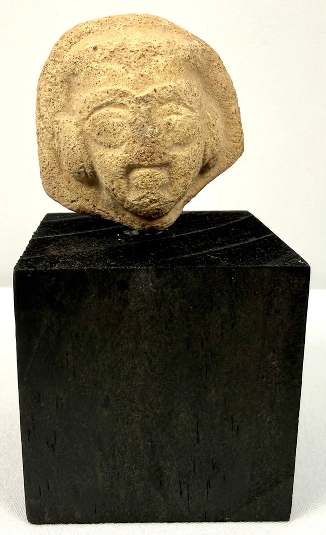 Frontal view of Ancient Near Eastern terracotta head fragment with defined beard and arched brows