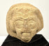 Ancient Eastern Mediterranean terracotta sculpture fragment with almond-shaped eyes, arched brows, and detailed facial hair.