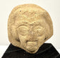 Ancient Eastern Mediterranean terracotta sculpture fragment with almond-shaped eyes, arched brows, and detailed facial hair.