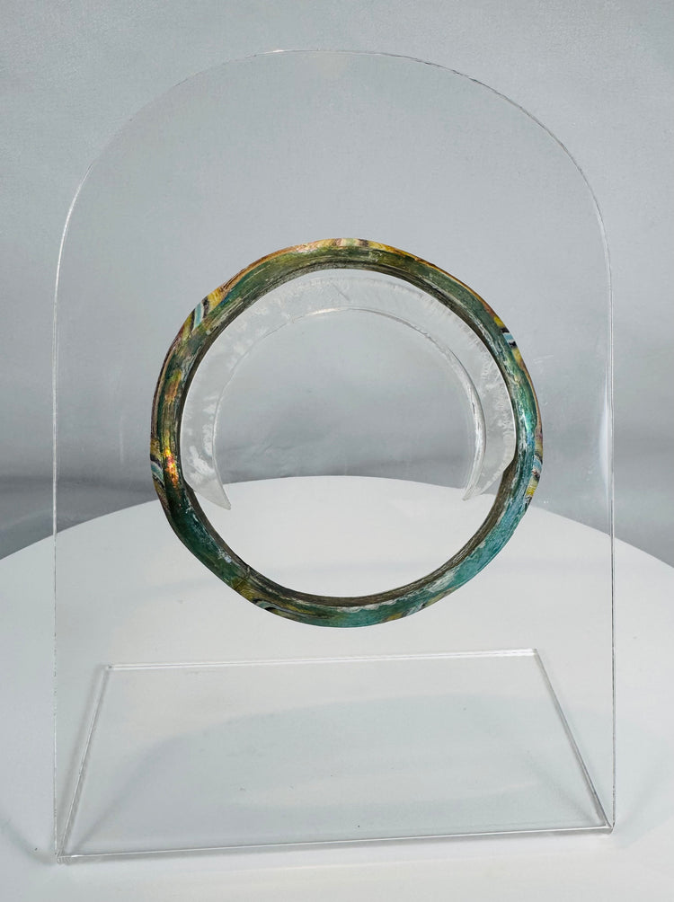 Ancient Roman polychrome glass bracelet displaying intricate striped decoration and archaeological iridescence.