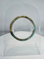 Ancient Roman polychrome glass bracelet displaying intricate striped decoration and archaeological iridescence.