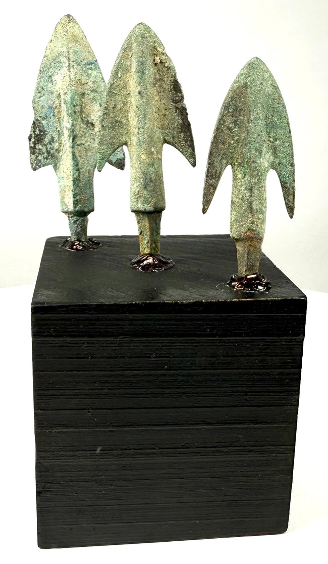 Green patinated bronze arrowheads with barbs mounted on black block