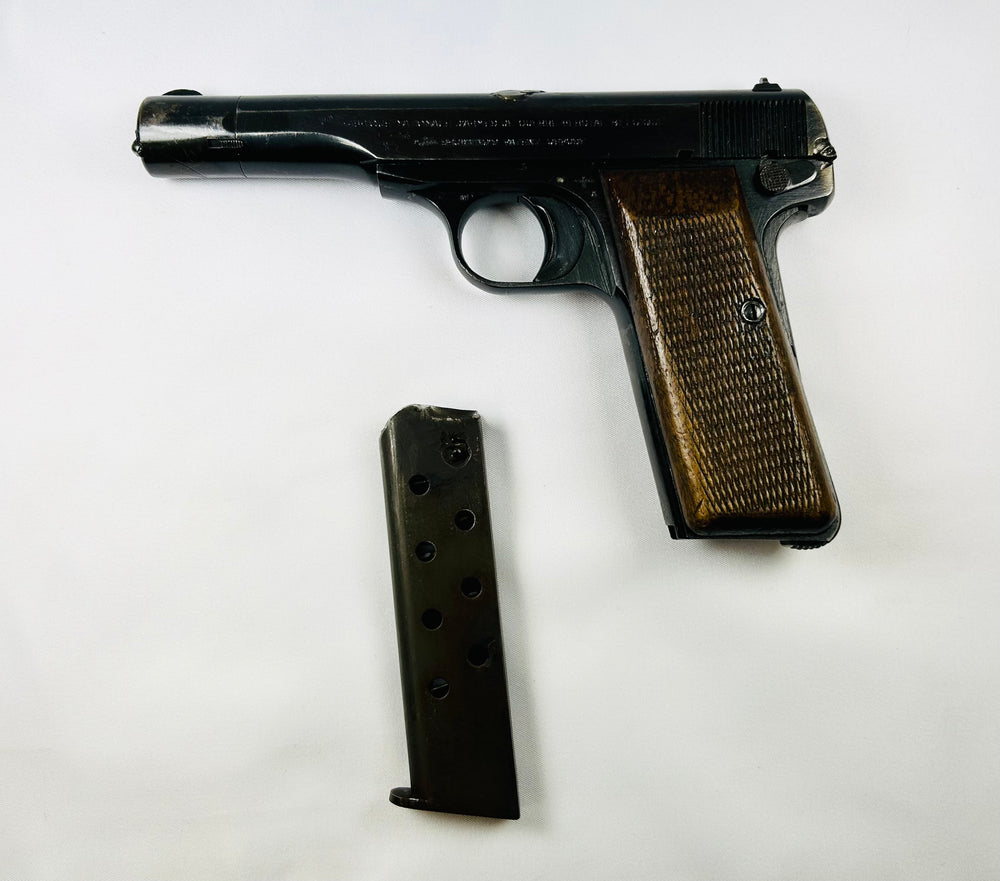Belgian Browning Fabrique Nationale Model 1922 pistol with wooden grips and magazine, displayed on white background — WWII-era firearm from German occupation of Belgium, 1941–1944.