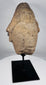 African sculptural stone fragment with conical headdress and solemn expression