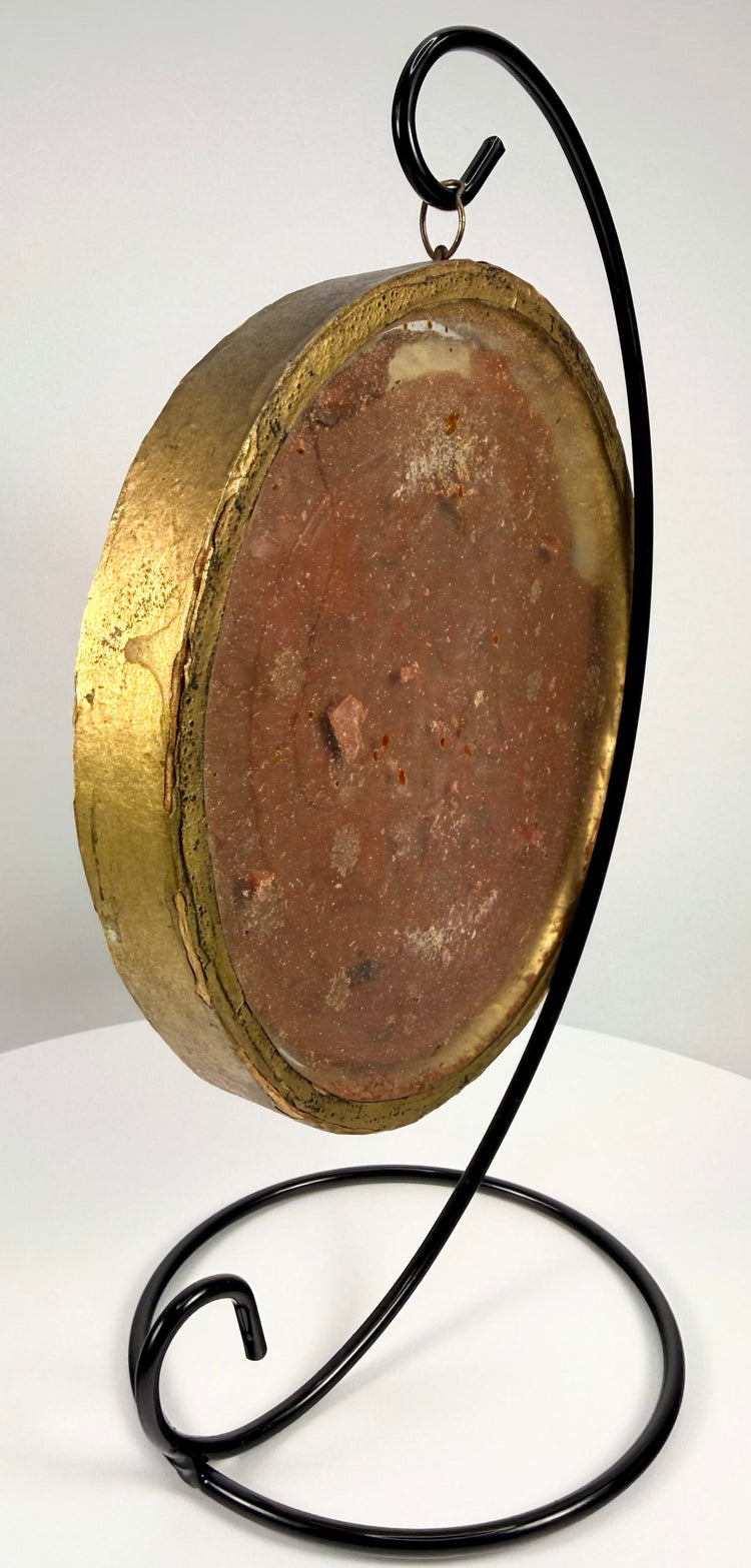 Gold-rimmed glass frame holding historical royal wax artifact