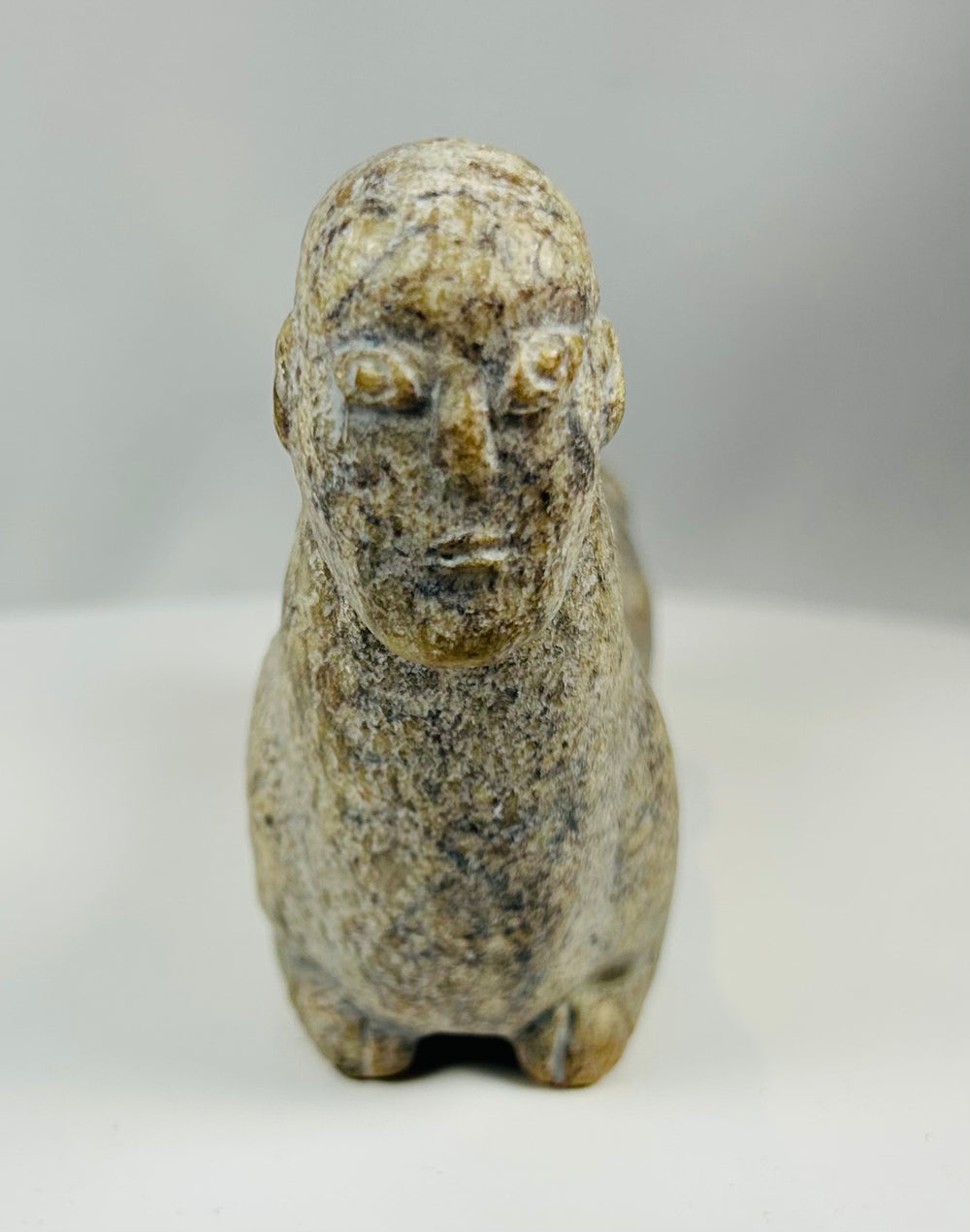 Hand carved stone effigy from West Africa with elongated body and upright neck