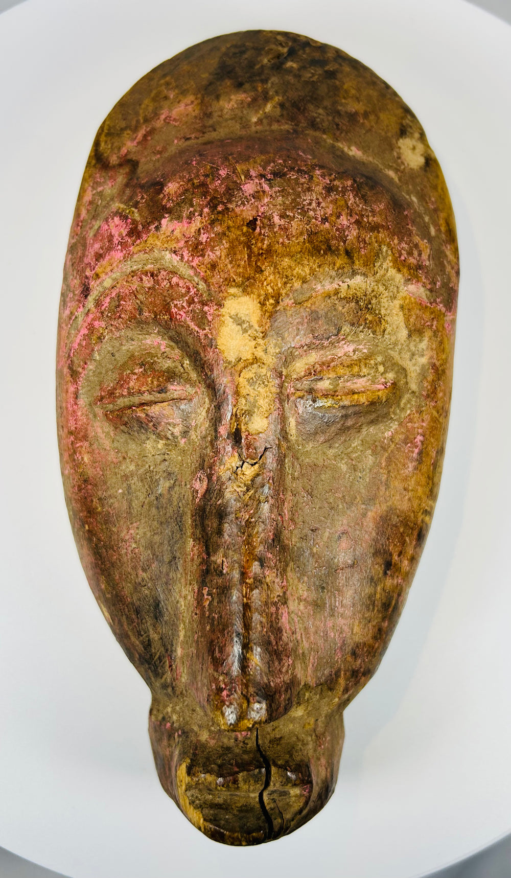 West African carved wood mask with symmetrical facial design