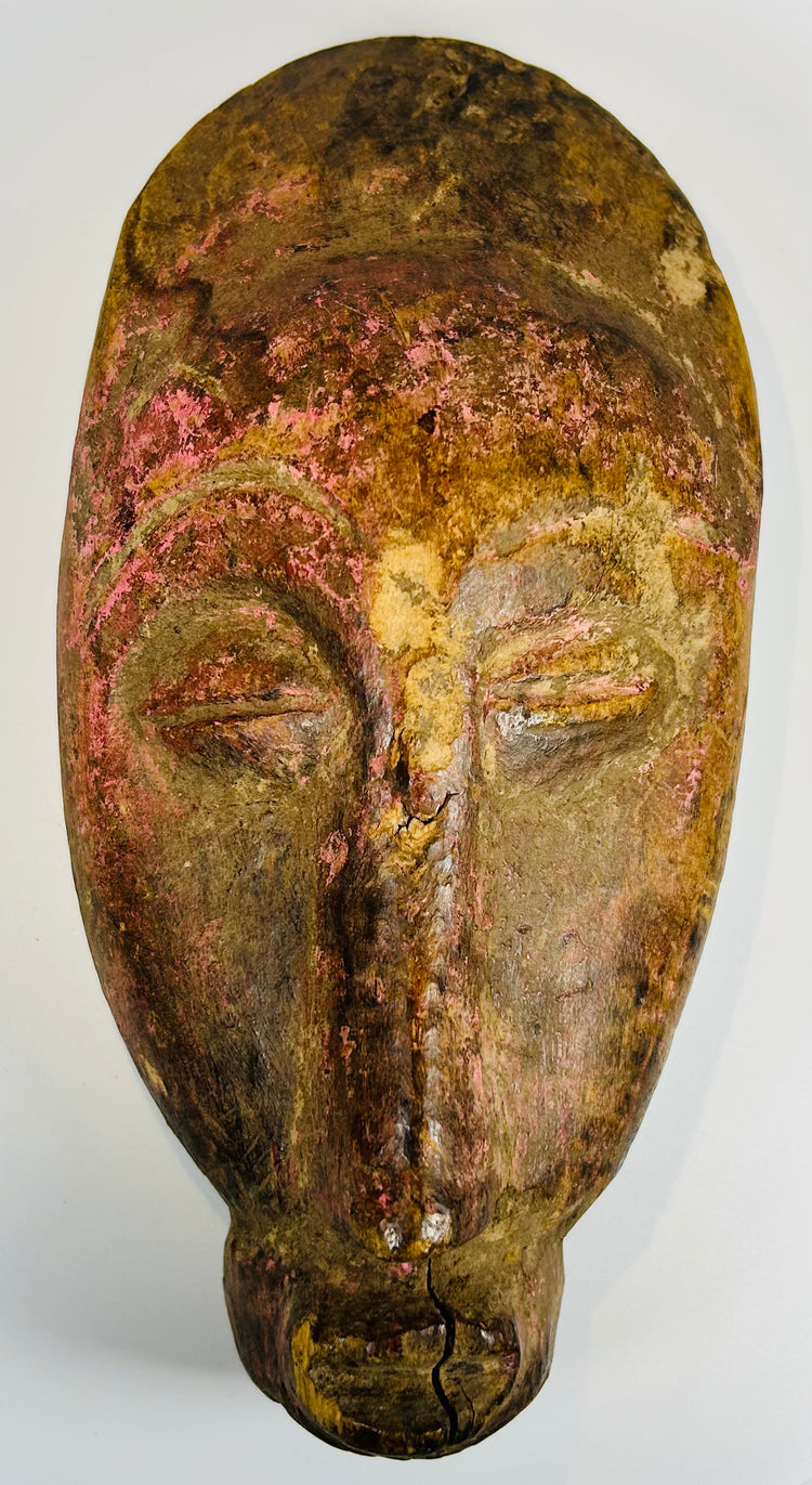 Hand carved African tribal mask with almond eyes and serene expression
