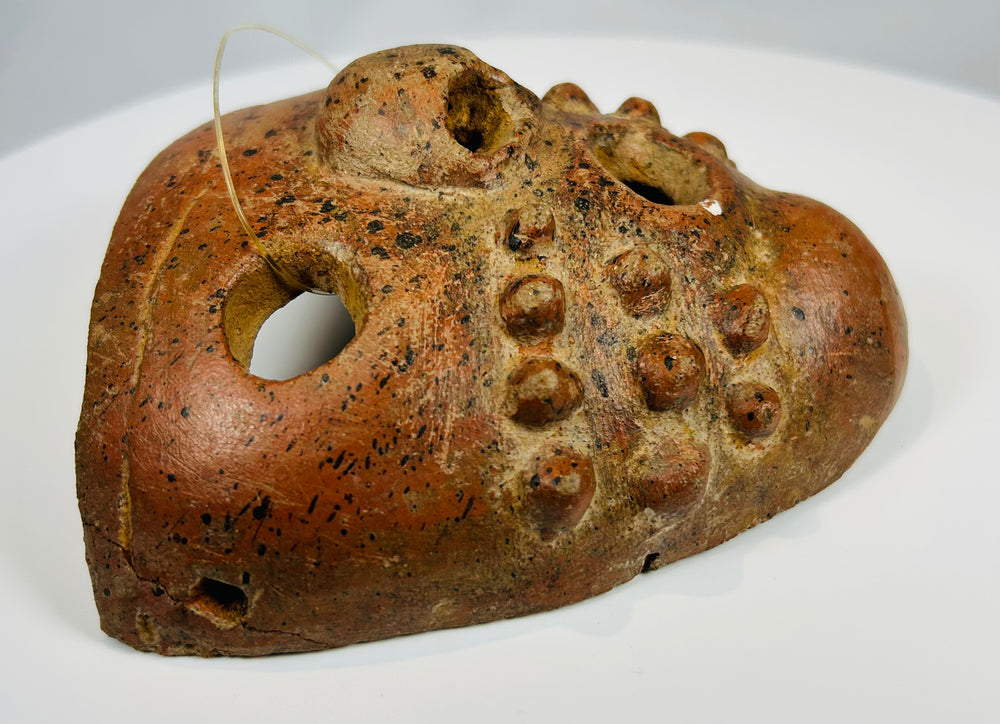 Terracotta ritual mask with applied nodules and suspension holes