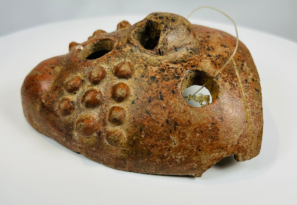 Ancient Central American mask with exaggerated eyes and sculptural form