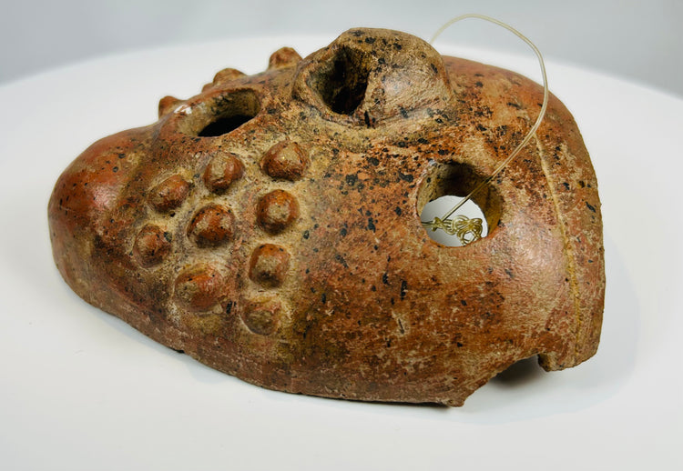 Ancient Central American mask with exaggerated eyes and sculptural form