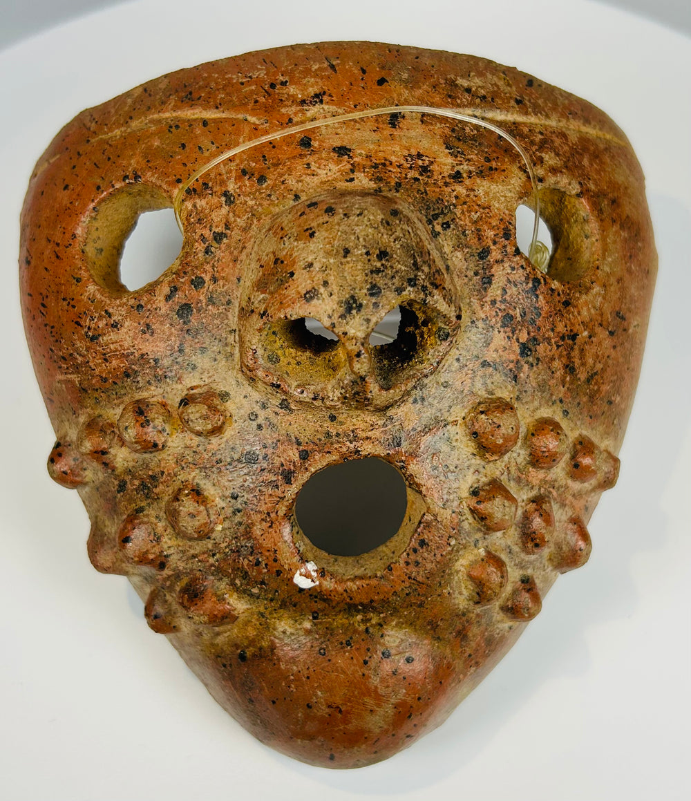 Pre-Columbian ritual mask with perforations and expressive form