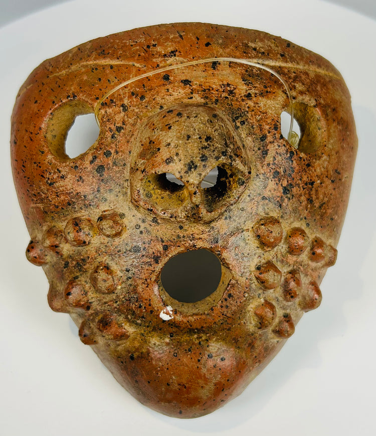 Pre-Columbian ritual mask with perforations and expressive form