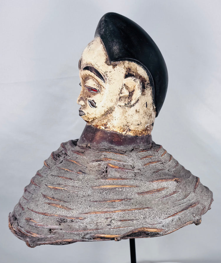 Yoruba Egungun ancestral headdress featuring black coiffure, painted wood face, and surviving costume framework.