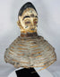 Mid-20th century Yoruba Egungun ceremonial headdress with white-painted face, red eyes, and woven fiber structure.
