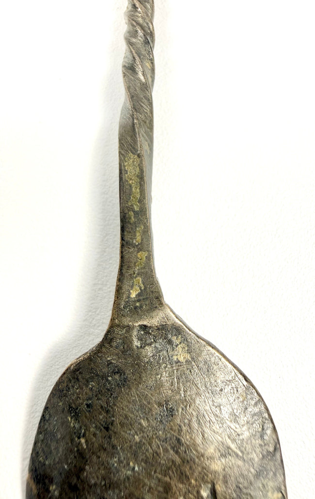 ancient Roman bronze spoon featuring an intricately twisted handle, oval bowl, and centuries-old green and brown patina.