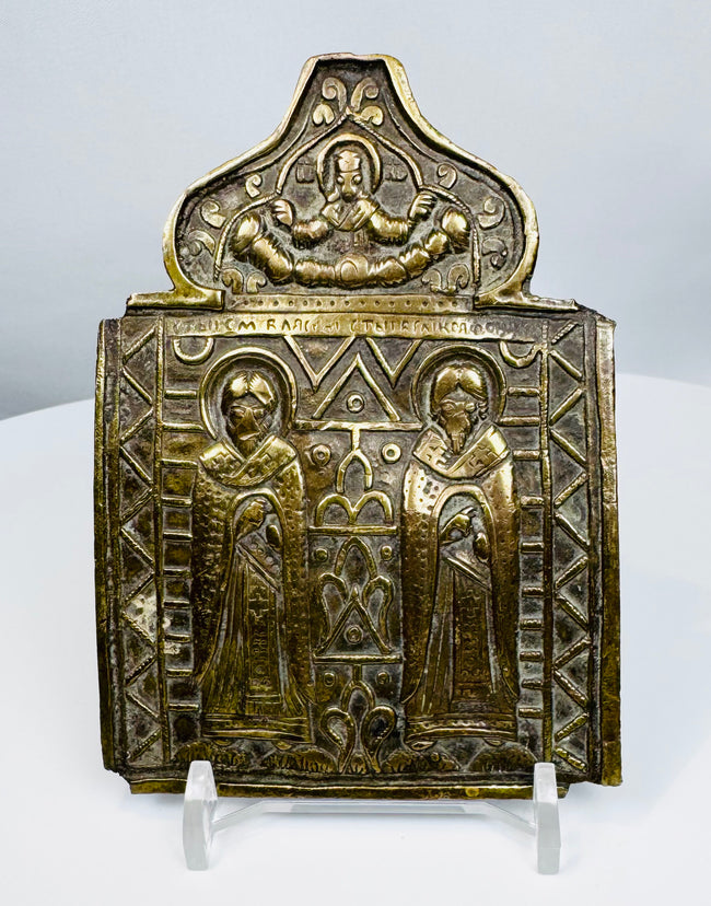 Nineteenth-century Russian Orthodox bronze folding icon center panel depicting two haloed saints and Christ above.