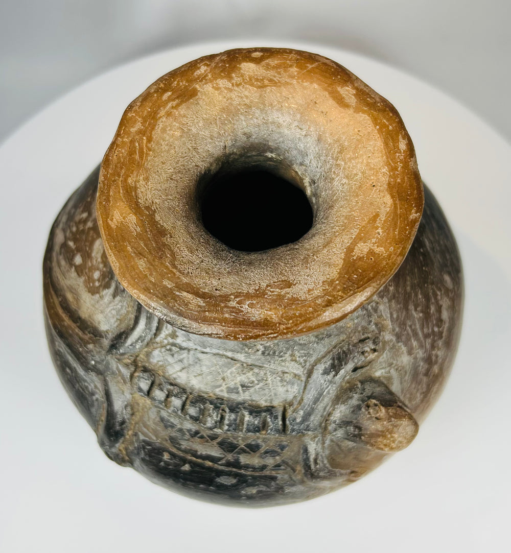 Terracotta vessel with stylized reptilian forms and archaeological wear