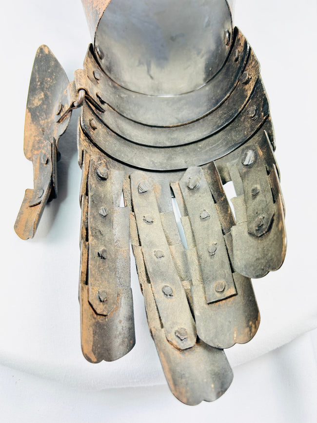 16th–17th-century style armoured gauntlet, forged steel construction, photographed on plain white.