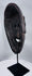 Traditional Timorese wooden mask with expressive monkey-like features and open mouth with protruding tongue.