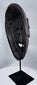 Traditional Timorese wooden mask with expressive monkey-like features and open mouth with protruding tongue.