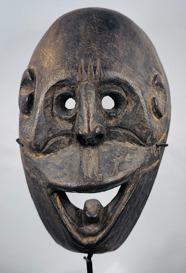 West Timor ceremonial mask hand-carved from hardwood with expressive simian features and aged patina.
