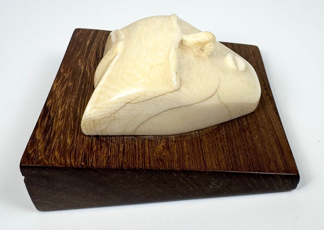 Hand-carved bone mask-form sculpture showcasing a contemplative expression, natural patina, and elegant mid-century modern design.