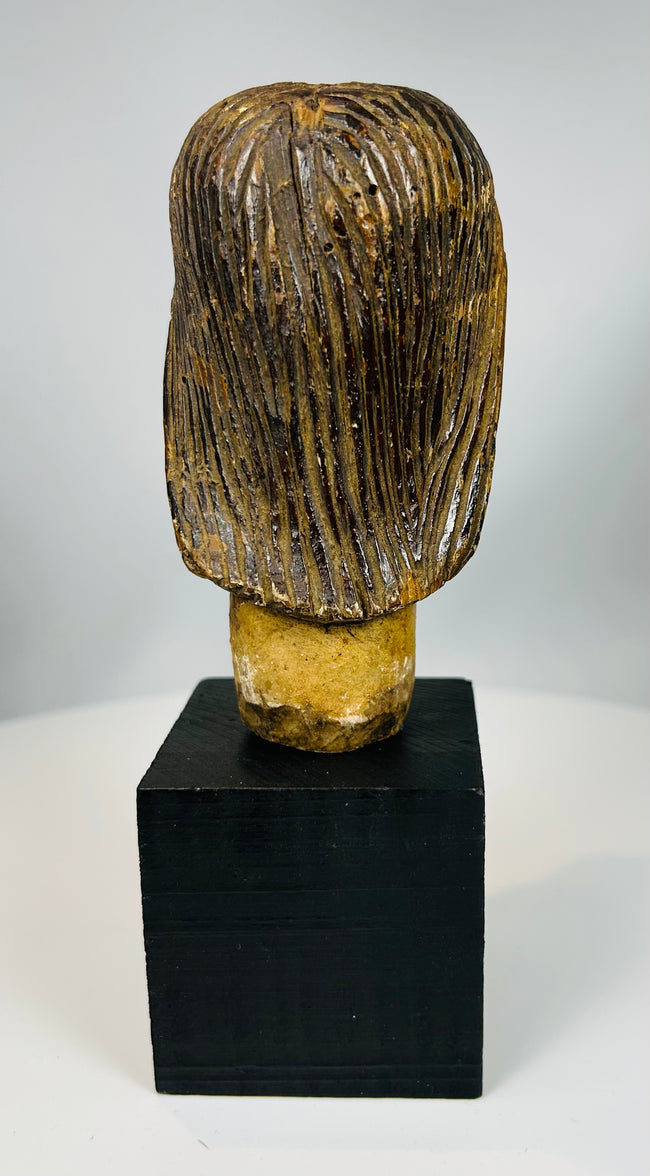 Carved Christ head mounted on display base with aged surface