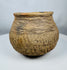 Historic Casas Grandes ceramic vessel from northern Mexico with wide mouth opening, corrugated shoulder bands, and mineral deposits.