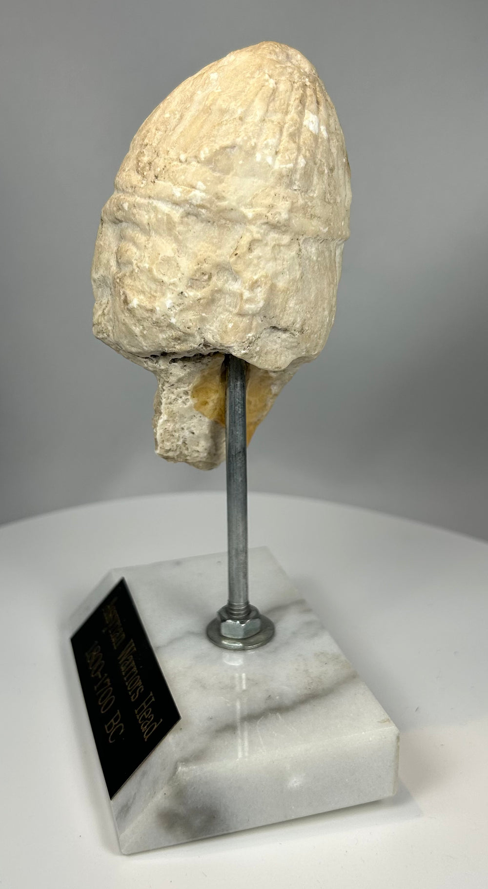 Early Assyrian sculpture of warrior with stylized facial features