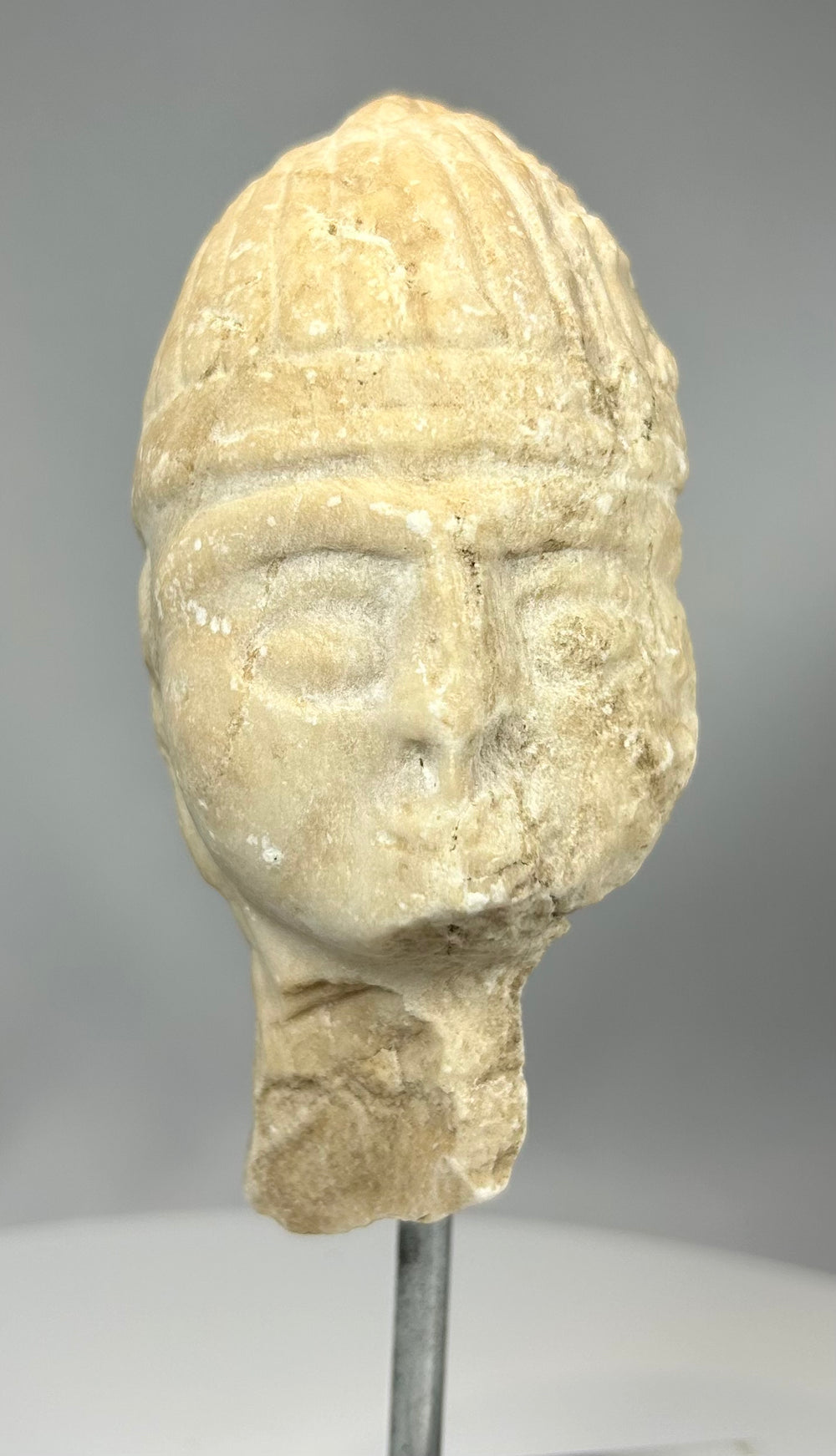 Assyrian carved stone head mounted on marble display base