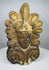Hand-molded Greek terracotta roof ornament inspired by ancient Mediterranean architecture, featuring a human face and ornate palmette design.