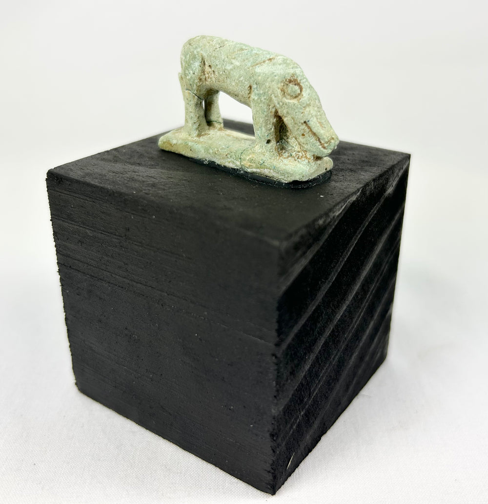 Ancient Egypt shrew-mouse amulet, pale green faience with mineral accretions, votive temple offering.