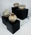 Four miniature Thai stoneware containers with transparent glaze and painted ornamentation, mounted on custom display stands.